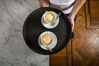 Two cups coffee with latte art tray