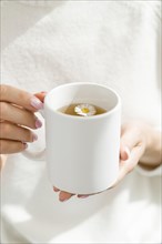 High angle woman holding white mug with tea