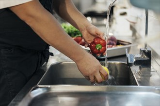 Side view male chef washing vegetables