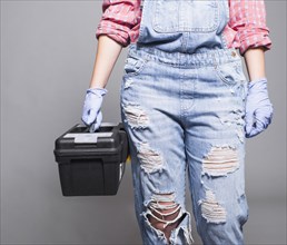 Woman overall holding tool box