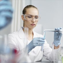 Front view female researcher laboratory with test tubes safety glasses