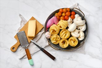Metal tray with raw ingredients for mushroom pasta