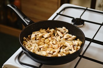 Frying champignon mushrooms in a frying pan