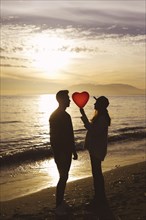 Couple heart balloon sea shore evening
