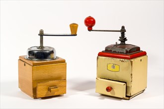 Old wooden colored manual coffee grinders on white background