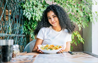 Portrait of smiling girl eating caesar salad. Concept of healthy food and healthy life
