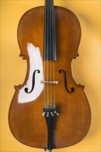 Wooden violin with string yellow background