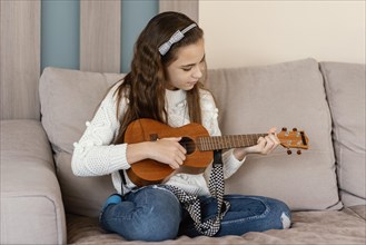 Girl home playing guitar