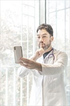 Latino doctor having video conference with his phone