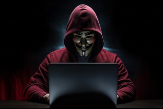 Hacker with Anonymous mask on notebook