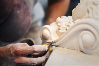 A plasterer restores a stucco figure