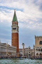 Famous view of St Mark campanile and columns with lion and saint by waterfront of piazzetta of St Mark square on Grand Canal