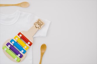 Flat lay baby clothes with xylophone