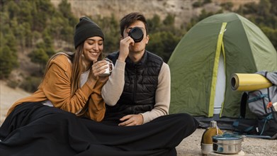 Couple camping drinking tea together