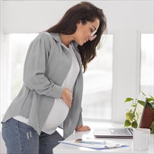 Side view pregnant woman working laptop home