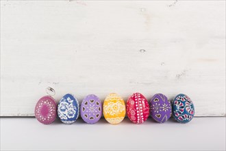 Row colorful eggs wood