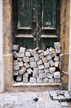A pile of stones in front of a house door in Lisbon