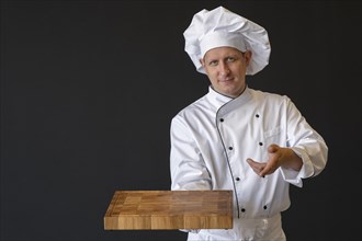 Medium shot chef holding wooden board