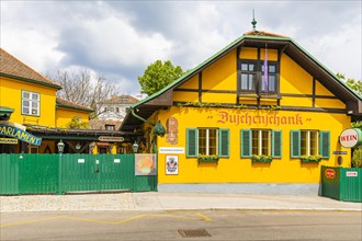 Buschenschank with yellow facade and green shutters