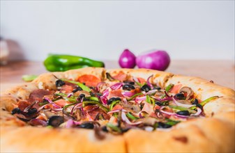 Supreme pizza with olives and vegetables on wooden table with space for text. Delicious supreme pizza with vegetables served on table