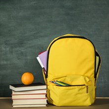 Yellow backpack stack books orange