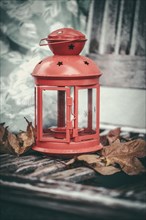 Red lantern standing on an old wooden bench