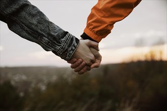 Couple holding hands while road trip together