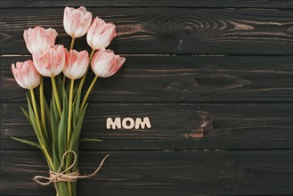 Mom inscription with tulips bouquet table