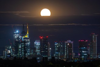 The super full moon rises behind the Frankfurt bank skyline