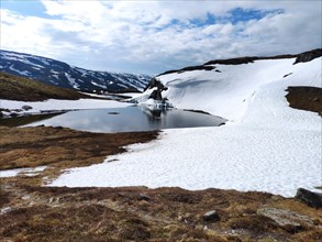 Lake surrounded by snow-capped mountain