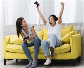 Excited women home playing video games together
