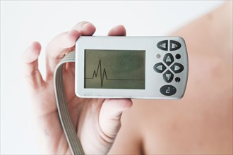 Person hand holding monitor with cardiogram