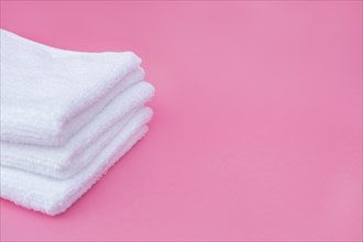 Stack white towels pink background