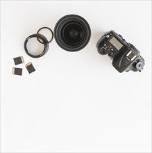 Top view dslr camera memory cards camera lens with extension rings white backdrop