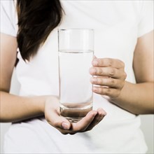 Crop female hands holding glass water