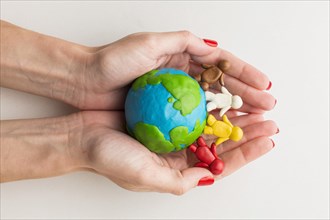 Top view hands holding plasticine globe people