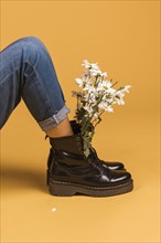 Sitting female legs boots with flowers inside