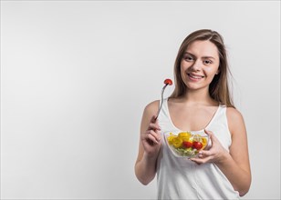 Smiling young woman with bowl salad