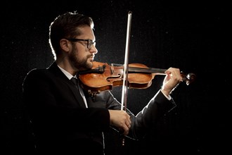 Side view male artist playing violin