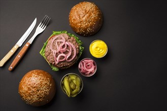 Top view beef burger with sauces cutlery