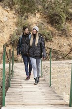 Couple with backpack walking bridge