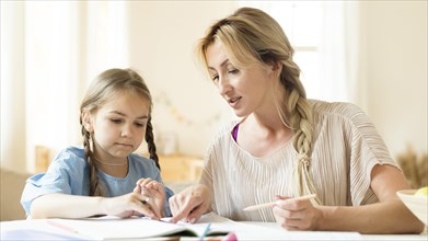 Mother helping her daughter her homework