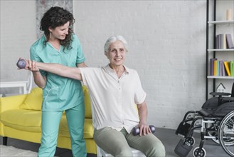 Physiotherapist working elderly patient modern clinic