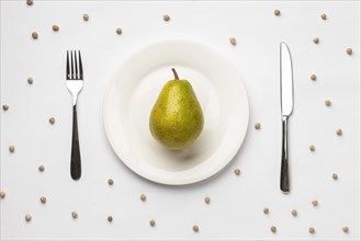 Flat lay fresh pear plate with cutlery