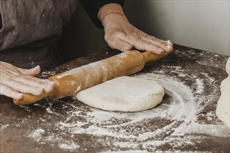 Female chef using rolling pin pizza dough