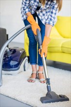 Close up woman s hand cleaning carpet with vacuum cleaner