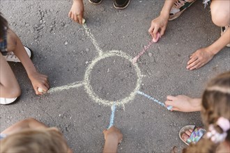 Kids drawing sun with chalk