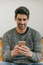 Smiling man browsing smartphone