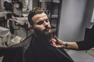 Unrecognizable barber cutting beard