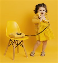 Cute child posing while holding telephone